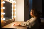 Woman Sitting in Front of a Make-up Mirror