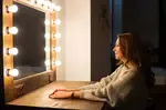 Woman Sitting in Front of a Make-up Mirror