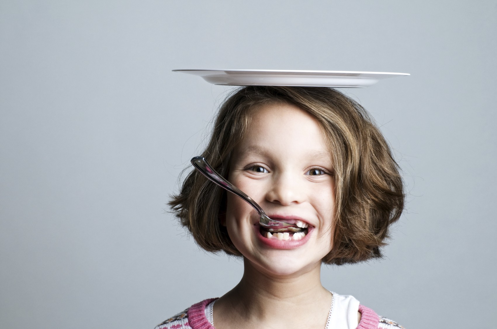 Girl wearing plate and spoon