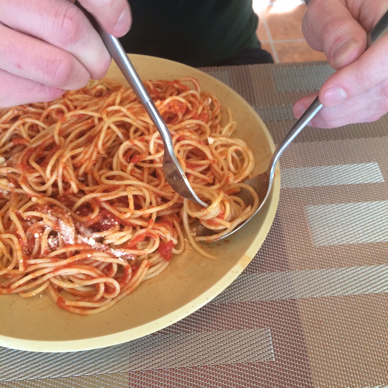 Using a spoon to put spaghetti on a fork